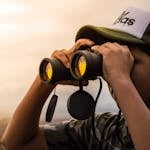 Man Looking in Binoculars during Sunset