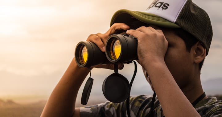 Man Looking in Binoculars during Sunset